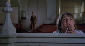 Movie still from “The Other” (1972), directed by Robert Mulligan – A young boy sitting in front of a pool table; Close Up shot, Low angle