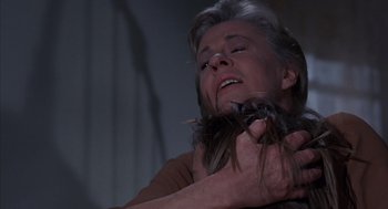 Movie still from “The Other” (1972), directed by Robert Mulligan – An older woman is holding her head down; Close Up shot, Over the shoulder angle