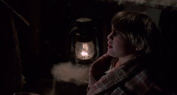 Movie still from “The Other” (1972), directed by Robert Mulligan – A young boy is wrapped in a blanket and looking at a lantern; Close Up shot, Low angle