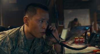 Movie still from “The Outpost” (2019), directed by Rod Lurie – A man in fatigues talking on a phone; Close Up shot, Low angle