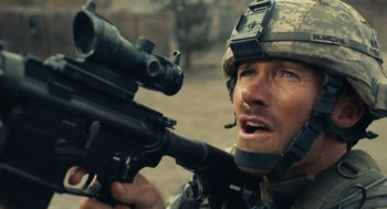 Movie still from “The Outpost” (2019), directed by Rod Lurie – A man in a military uniform is holding a rifle; Close Up shot, Over the shoulder angle