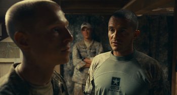 Movie still from “The Outpost” (2019), directed by Rod Lurie – A group of men standing next to each other in a room; Medium shot, Over the shoulder angle