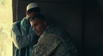 Movie still from “The Outpost” (2019), directed by Rod Lurie – A man in fatigues is sitting next to another man in fatigues; Close Up shot, Over the shoulder angle
