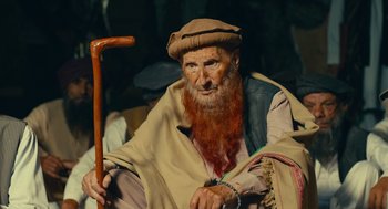 Movie still from “The Outpost” (2019), directed by Rod Lurie – An old man with a long red beard holding a cane; Close Up shot, Low angle