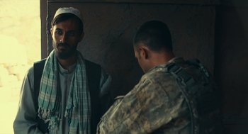 Movie still from “The Outpost” (2019), directed by Rod Lurie – Two men in fatigues are talking to each other; Medium shot, Over the shoulder angle