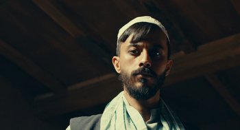 Movie still from “The Outpost” (2019), directed by Rod Lurie – A man with a beard wearing a white hat; Close Up shot, Low angle