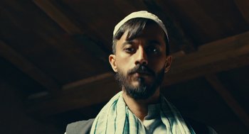 Movie still from “The Outpost” (2019), directed by Rod Lurie – A man with a beard wearing a white hat; Close Up shot, Low angle