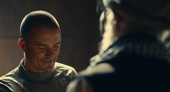 Movie still from “The Outpost” (2019), directed by Rod Lurie – A man with a shaved head talking to another man; Close Up shot, Over the shoulder angle