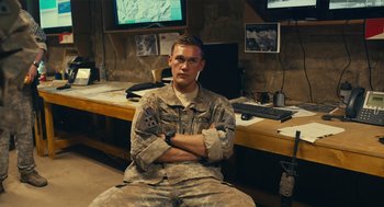 Movie still from “The Outpost” (2019), directed by Rod Lurie – A man sitting in front of a computer monitor; Medium shot, Over the shoulder angle