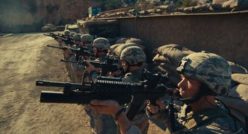 Movie still from “The Outpost” (2019), directed by Rod Lurie – A group of men in fatigues are holding guns; Wide shot, High angle