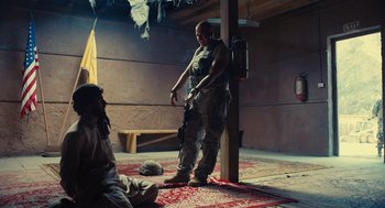 Movie still from “The Outpost” (2019), directed by Rod Lurie – A man holding a gun while standing next to a woman; Wide shot, Over the shoulder angle