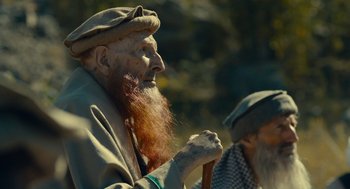 Movie still from “The Outpost” (2019), directed by Rod Lurie – A man with a long red beard is holding a stick; Close Up shot, Low angle