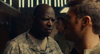 Movie still from “The Outpost” (2019), directed by Rod Lurie – A man in military fatigues talking to another man in fatigues; Close Up shot, Over the shoulder angle