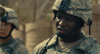 Movie still from “The Outpost” (2019), directed by Rod Lurie – A person wearing a uniform; Close Up shot, Over the shoulder angle