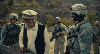 Movie still from “The Outpost” (2019), directed by Rod Lurie – A group of men standing next to each other on top of a hill; Medium shot, Over the shoulder angle