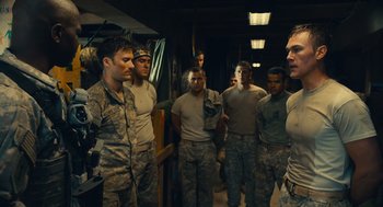 Movie still from “The Outpost” (2019), directed by Rod Lurie – A group of men standing next to each other in uniform; Medium shot, Over the shoulder angle