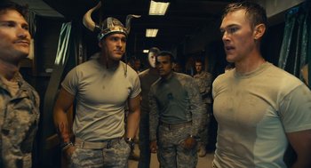 Movie still from “The Outpost” (2019), directed by Rod Lurie – A group of men walking in a hallway wearing military uniforms; Medium shot, Over the shoulder angle