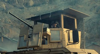 Movie still from “The Outpost” (2019), directed by Rod Lurie – A man sitting in the driver's seat of an armored vehicle; Medium shot, Low angle