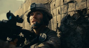Movie still from “The Outpost” (2019), directed by Rod Lurie – A man in a military uniform is holding a gun; Close Up shot, Over the shoulder angle