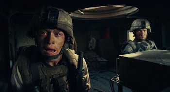 Movie still from “The Outpost” (2019), directed by Rod Lurie – A man in military fatigues is holding a rifle; Close Up shot, Low angle