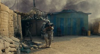 Movie still from “The Outpost” (2019), directed by Rod Lurie – A group of men in uniform are standing in the dirt; Wide shot, High angle