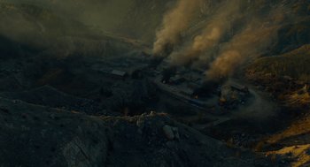 Movie still from “The Outpost” (2019), directed by Rod Lurie – Smoke billows from a fire on a hillside; Extreme Wide shot, High angle