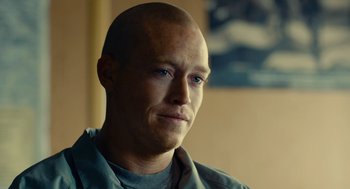 Movie still from “The Outpost” (2019), directed by Rod Lurie – A man with a shaved head is looking at the camera; Close Up shot, Over the shoulder angle