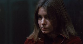 Movie still from “The Panic in Needle Park” (1971), directed by Jerry Schatzberg – A woman with long brown hair wearing a red jacket; Close Up shot, Low angle