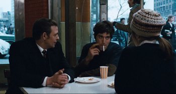 Movie still from “The Panic in Needle Park” (1971), directed by Jerry Schatzberg – A group of men sitting at a table drinking coffee; Medium shot, Over the shoulder angle