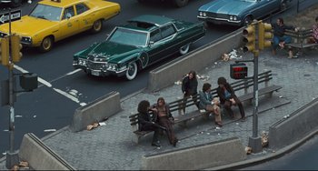 Movie still from “The Panic in Needle Park” (1971), directed by Jerry Schatzberg – A group of people sitting on top of a wooden bench; Wide shot, High angle