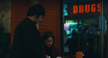 Movie still from “The Panic in Needle Park” (1971), directed by Jerry Schatzberg – A man and a woman sitting in front of a table; Medium shot, Over the shoulder angle