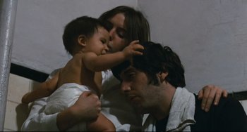 Movie still from “The Panic in Needle Park” (1971), directed by Jerry Schatzberg – A man and a woman and a baby in a room; Medium shot, High angle