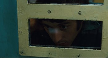 Movie still from “The Panic in Needle Park” (1971), directed by Jerry Schatzberg – A man looking through a window in a train; Close Up shot, High angle