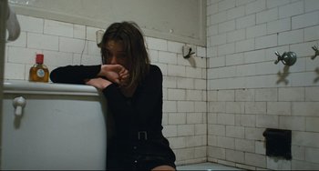 Movie still from “The Panic in Needle Park” (1971), directed by Jerry Schatzberg – A woman sitting on the edge of a sink in a bathroom; Medium shot, High angle