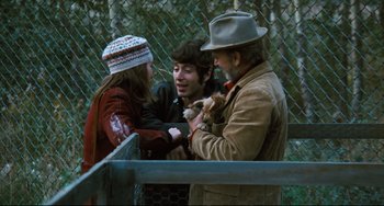 Movie still from “The Panic in Needle Park” (1971), directed by Jerry Schatzberg – A group of people standing next to each other near a chain link fence; Medium shot, Over the shoulder angle