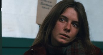 Movie still from “The Panic in Needle Park” (1971), directed by Jerry Schatzberg – A woman with long brown hair sitting in a room; Close Up shot, Low angle