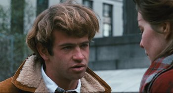 Movie still from “The Panic in Needle Park” (1971), directed by Jerry Schatzberg – A young man with long blonde hair wearing a fur coat; Close Up shot, Low angle