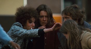 Movie still from “The Panic in Needle Park” (1971), directed by Jerry Schatzberg – A group of people standing next to each other on a street; Medium shot, Low angle