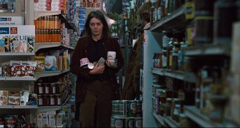 Movie still from “The Panic in Needle Park” (1971), directed by Jerry Schatzberg – A woman walking through a store filled with lots of food; Medium shot, Low angle