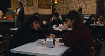 Movie still from “The Panic in Needle Park” (1971), directed by Jerry Schatzberg – A group of people sitting at a table drinking coffee; Medium shot, Over the shoulder angle