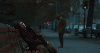 Movie still from “The Panic in Needle Park” (1971), directed by Jerry Schatzberg – A man sitting on top of a bench next to another man; Wide shot, Over the shoulder angle