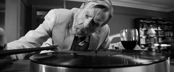 Movie still from “The Party” (2017), directed by Sally Potter – An older man is looking at a record player; Close Up shot, Low angle