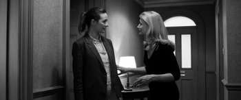 Movie still from “The Party” (2017), directed by Sally Potter – Two women standing next to each other in front of a lamp; Medium shot, Over the shoulder angle