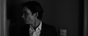 Movie still from “The Party” (2017), directed by Sally Potter – Black and white photograph of a man in a suit; Close Up shot, Low angle