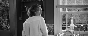 Movie still from “The Party” (2017), directed by Sally Potter – A black and white photo of a woman looking out a window; Medium shot, Over the shoulder angle