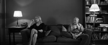 Movie still from “The Party” (2017), directed by Sally Potter – A man and a woman sitting on a couch; Medium shot, Low angle