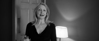 Movie still from “The Party” (2017), directed by Sally Potter – A black and white photo of a woman standing in front of a lamp; Close Up shot, Low angle