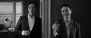 Movie still from “The Party” (2017), directed by Sally Potter – A man and a woman standing next to each other holding wine glasses; Medium shot, Over the shoulder angle