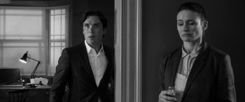 Movie still from “The Party” (2017), directed by Sally Potter – A black and white photo of a man in a suit; Medium shot, Over the shoulder angle