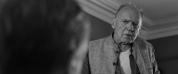 Movie still from “The Party” (2017), directed by Sally Potter – An older man wearing a jacket and a tie; Close Up shot, Over the shoulder angle
